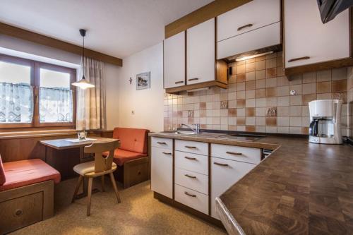 a kitchen with white cabinets and a counter top at Garnì Piz da L'Ander in Corvara in Badia
