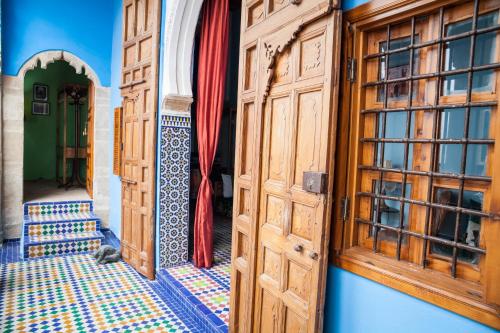 an entrance to a house with wooden doors and a tile floor at Dar Shaeir in Rabat