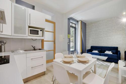 une cuisine et un salon avec une table et des chaises blanches dans l'établissement Charming apartment - 1BR-4P - Montparnasse, à Paris