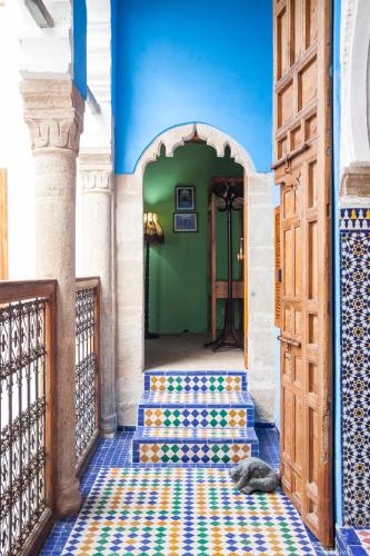 a hallway with a door and a floor with colorful tiles at Dar Shaeir in Rabat