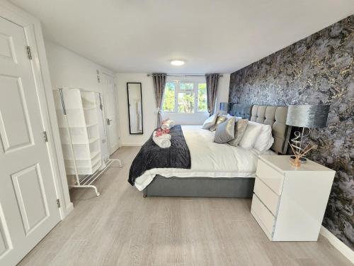 ein Schlafzimmer mit einem großen Bett und einer Wand in der Unterkunft Home From Home Wembley in Preston