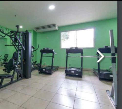 un gimnasio con paredes verdes y máquinas de correr en Apartamento no Joia da Barra, en Río de Janeiro