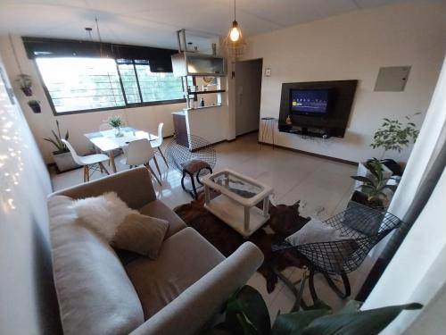 a living room with a couch and a table and a tv at Quintana Apartment in Mendoza