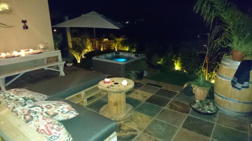a patio with a jacuzzi tub in a yard at night at Clanwilliam Oasis BnB Guest House - Naturism, Boating, Hiking & more in Clanwilliam