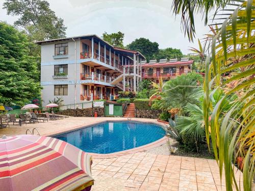 a hotel with a swimming pool in front of a building at Hotel Nahomi Divisamar by LHR in Manuel Antonio