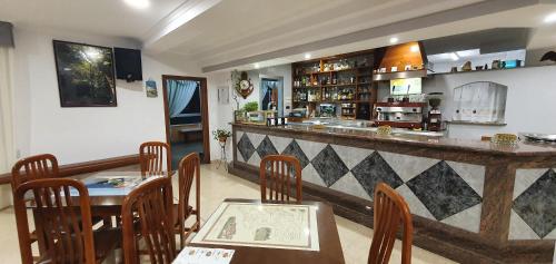 restauracja z barem z drewnianymi stołami i krzesłami w obiekcie Hotel La Costera w mieście A Lanzada