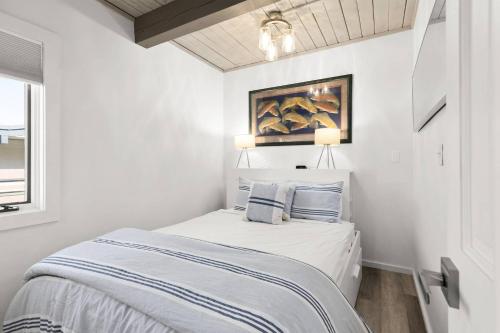 Dormitorio blanco con cama con almohadas azules en Aspenwood One Bedroom J3 en Snowmass Village