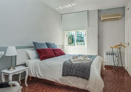 1 dormitorio con 1 cama con almohadas rojas y azules en Apartamento New Folch Sevilla A, en Sevilla