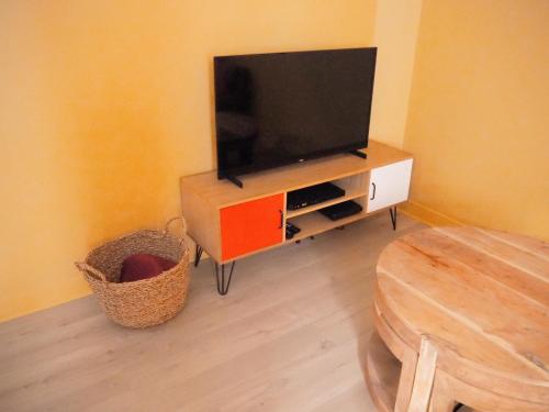 a living room with a flat screen tv on a cabinet at Maison Salamandre in Remoulins