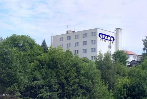 a tall building with a sign on the side of it at Penzion Starr in Havlickuv Brod