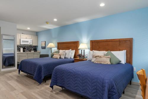Duas camas num quarto com paredes azuis em Extended Stay Gun Barrel City em Gun Barrel City