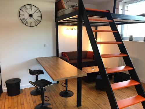 a loft bed with a desk and a table in a room at Studio - Mezzanine - Style loft industriel in Brindas