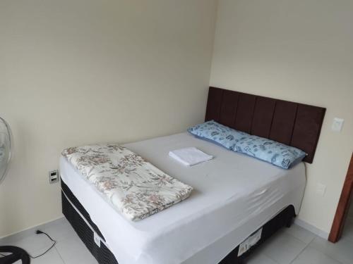 ein Bett mit zwei Kissen auf einem Zimmer in der Unterkunft Apartamento com garagem e perto das praias. in Palhoça