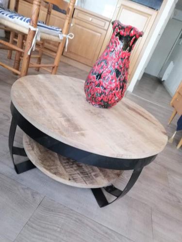 a vase sitting on top of a wooden table at Julie's Home in Bray-Dunes