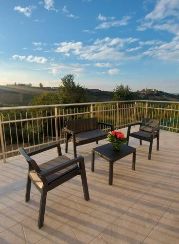 three benches and a vase of flowers on a patio at Roero Sunset in Govone