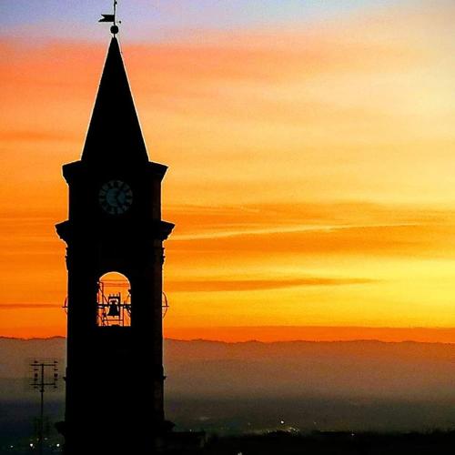 a clock tower with a sunset in the background at Roero Sunset in Govone