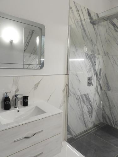 een witte badkamer met een wastafel en een douche bij Roero Sunset in Govone
