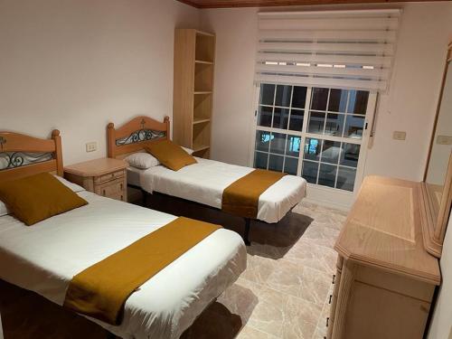 - une chambre avec 2 lits et une fenêtre dans l'établissement Apartamento vacacional en O Grove, à O Grove