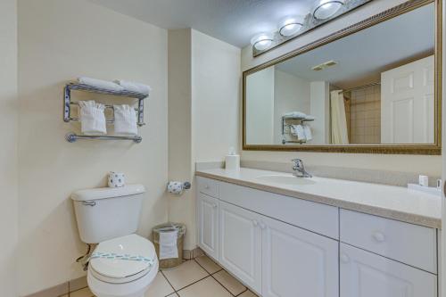 a bathroom with a toilet and a sink and a mirror at Daytona Beach Resort 803 in Daytona Beach