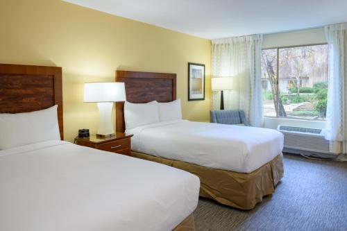 a hotel room with two beds and a window at Airtel Plaza Hotel in Van Nuys