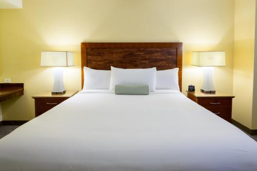 a bedroom with a large white bed with two lamps at Airtel Plaza Hotel in Van Nuys