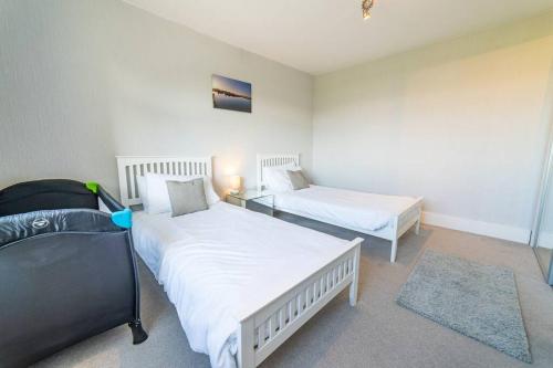 Un dormitorio con 2 camas, una mesa y una falda en Much loved home with a view., en Poole