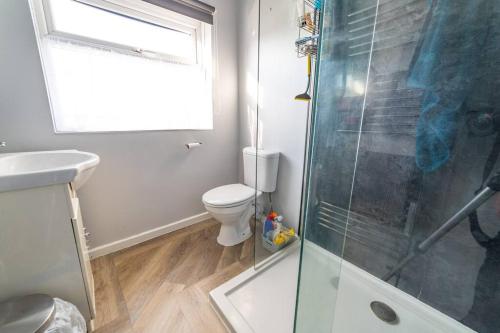 a bathroom with a toilet and a glass shower at Much loved home with a view. in Poole