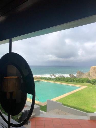a view of a pool from a house with a mirror at Herdade AMÁLIA RODRIGUES in Zambujeira do Mar