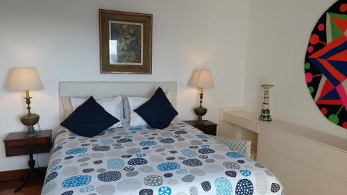 a bedroom with a bed with blue pillows at Herdade AMÁLIA RODRIGUES in Zambujeira do Mar
