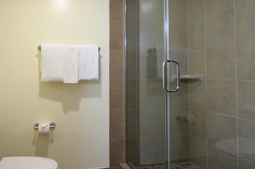a bathroom with a glass shower with a toilet at Airtel Plaza Hotel in Van Nuys