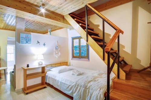 a bedroom with a bed and a staircase at Vavilato Home Kouramades in Kouramádes