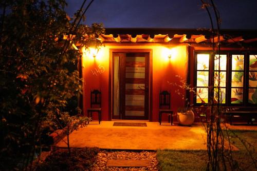 uma porta da frente de uma casa à noite em Recanto EmmAnnEssência em Gravatal