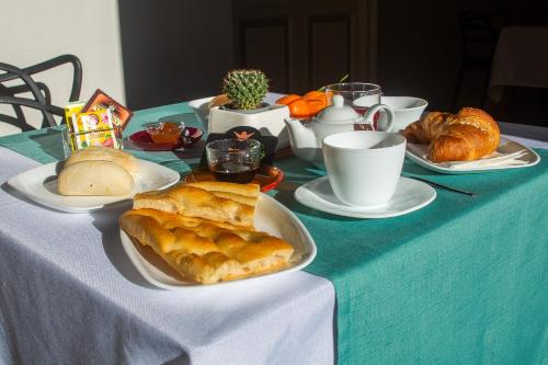 a table with plates of food and croissants on it at Il Giardino della Tartaruga in Genova