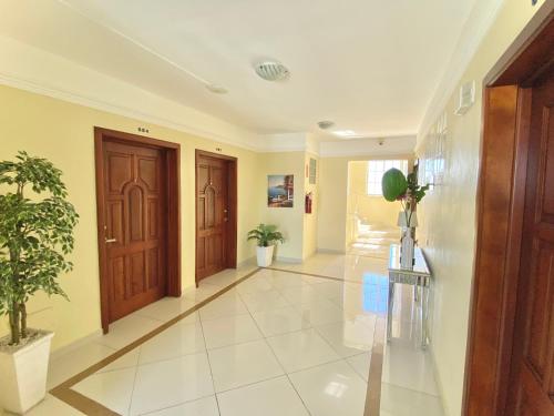 a hallway with two wooden doors and potted plants at Hotel Shakey in Santo Domingo