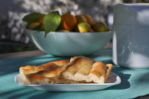 einen Teller mit einem Kuchen auf einem Tisch mit einer Schale Obst in der Unterkunft Il Giardino della Tartaruga in Genua