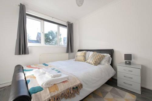 a bedroom with a bed and a window at Modern 1 Bed Maisonette, Contractor Friendly, Near Airport, Town Centre and Train Station in Luton