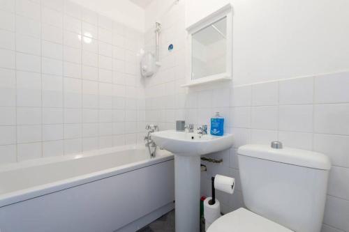 a white bathroom with a toilet and a sink at Modern 1 Bed Maisonette, Contractor Friendly, Near Airport, Town Centre and Train Station in Luton