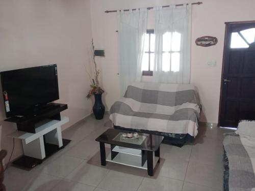 - un salon avec un lit, une télévision et une table dans l'établissement ALOJAMIENTO TEMPORARIO, à Paso de los Libres