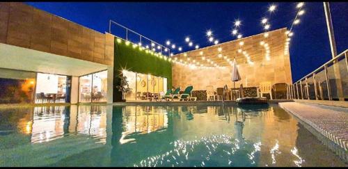 a swimming pool in a building with lights on it at Fuseta Ria Resort - Villa Jasmine - Pool, Jacuzzi & Sea Views in Fuzeta