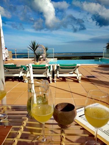 two glasses of wine sitting on top of a table at Fuseta Ria Resort - Villa Jasmine - Pool, Jacuzzi & Sea Views in Fuzeta