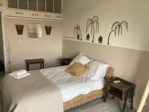 a bedroom with a bed with white sheets and pillows at Hôtel Paradis in Bormes-les-Mimosas