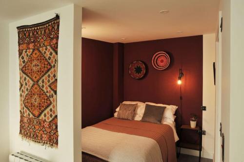 a bedroom with a bed and a red wall at No. 5 Bligh's Yard in Canterbury