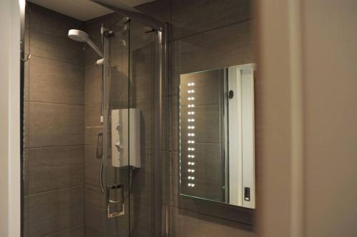 a bathroom with a shower with a mirror at No. 5 Bligh's Yard in Canterbury