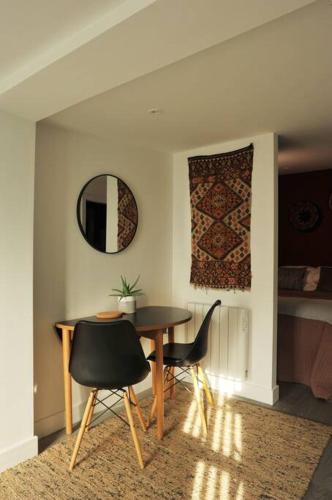 a dining room with a table and chairs and a mirror at No. 5 Bligh's Yard in Canterbury