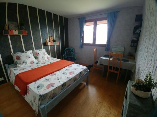 een slaapkamer met een bed, een tafel en een raam bij Rêverie Champêtre in Verrens-Arvey