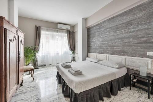 sypialnia z dużym łóżkiem i drewnianą ścianą w obiekcie Regina Luxury Flat w Rzymie