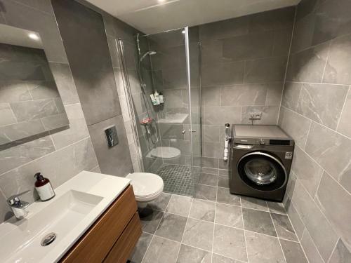 a bathroom with a washing machine in a shower at Astonishing Mountain Lodge at the top of Gaustablikk, 25m2 west facing terrace, 3 bedrooms in Gaustablikk