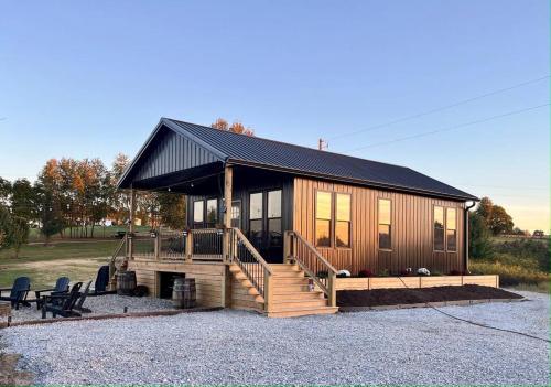 uma grande cabina de madeira com um telhado preto em Bourbon Barrel Cottages #2 of 5 on Kentucky trail em Lawrenceburg