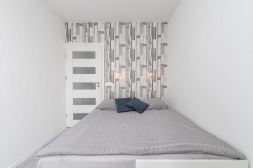 a bed in a white room with a headboard at Chill Apartment - Ludwika Rydygiera in Kraków