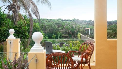 a balcony with a table and chairs with a laptop on it at Finca La Punta in Icod de los Vinos